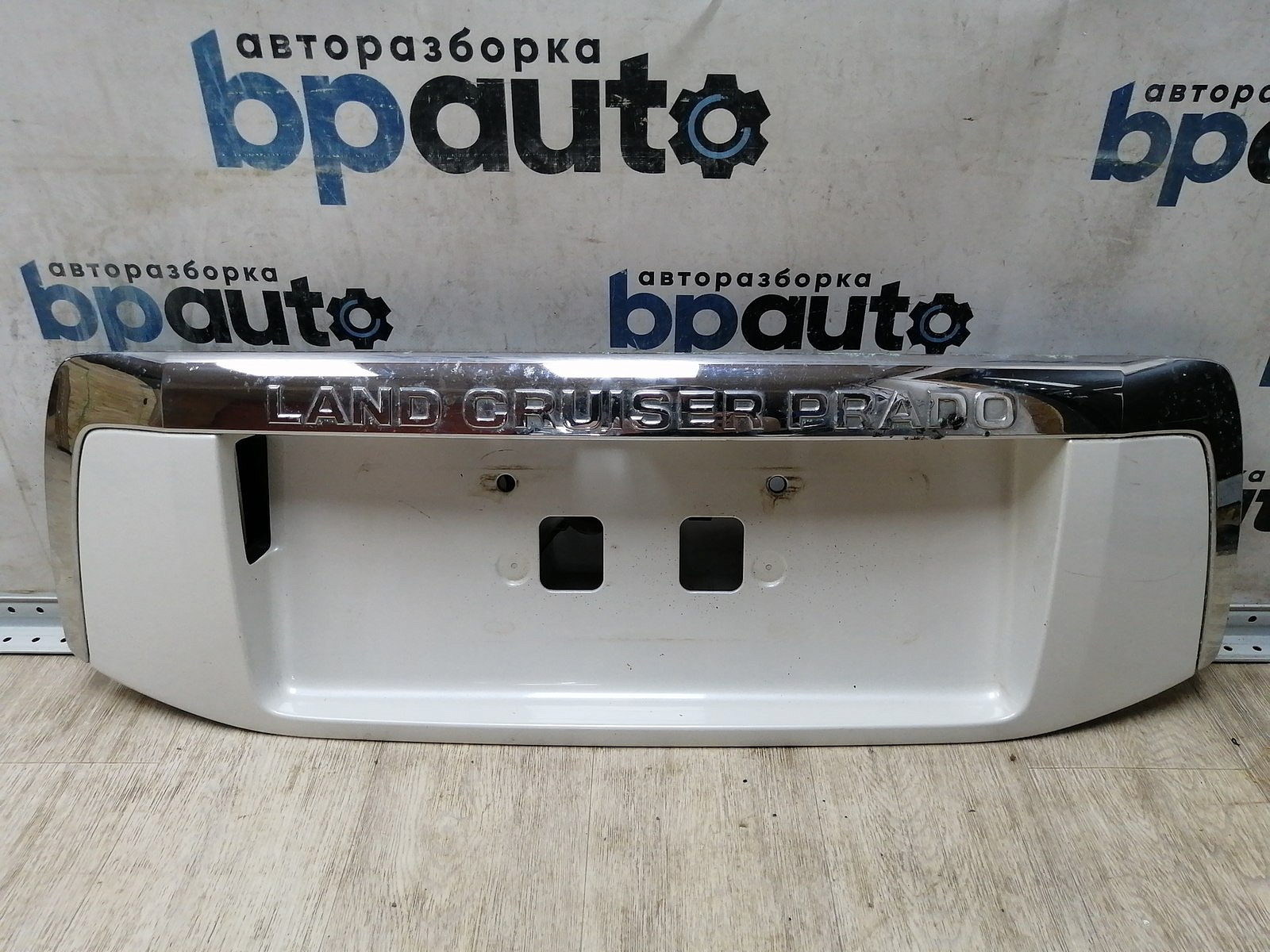 Пример детали Накладка крышки багажника, без кнопок (76811-60190); Toyota Land Cruiser Prado 150 (2010 — 2013) /AA045273/ БУ; Оригинал; Р0, Хорошее; (070) Белый перламутр 3х. сл.