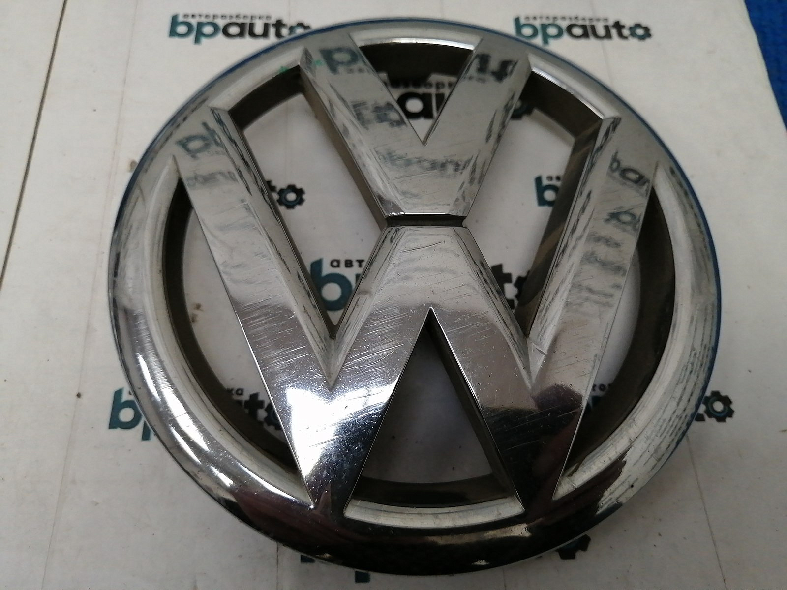 Пример детали Эмблема решетки радиатора (5K0853601F); Volkswagen Golf VI HB 5D (2008- 2012), VI Wagon (2008- 2012), VI HB 3D (2008- 2012) /AA038049/ БУ; Оригинал; Р1, Мелкий дефект; 