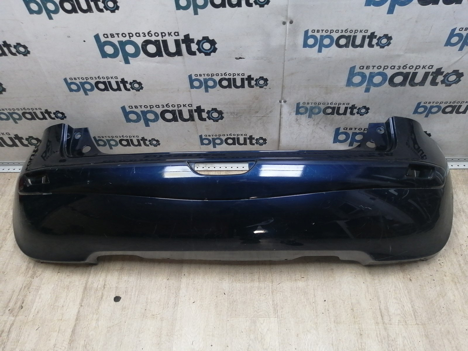 Пример детали Бампер задний; без паркт. (85022 9U040); Nissan Note I (2005-2009), I рест. (2009-2013) /AA046076/ БУ; Оригинал; Р1, Мелкий дефект; 