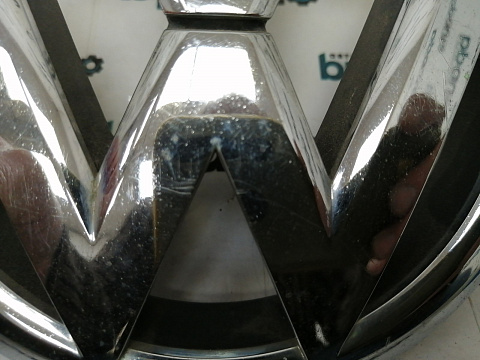 Фотография детали AA038051; Эмблема решетки радиатора (5K0853601) для Volkswagen Golf/БУ; Оригинал; Р1, Мелкий дефект; . Фото номер 2